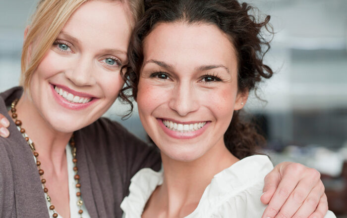 two women with radiant smiles after cosmetic teeth whitening